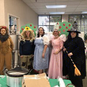 The team dressed up as the Wizard of Oz cast, a lion, the good & bad witches, the scarecrow, and Dorothy.