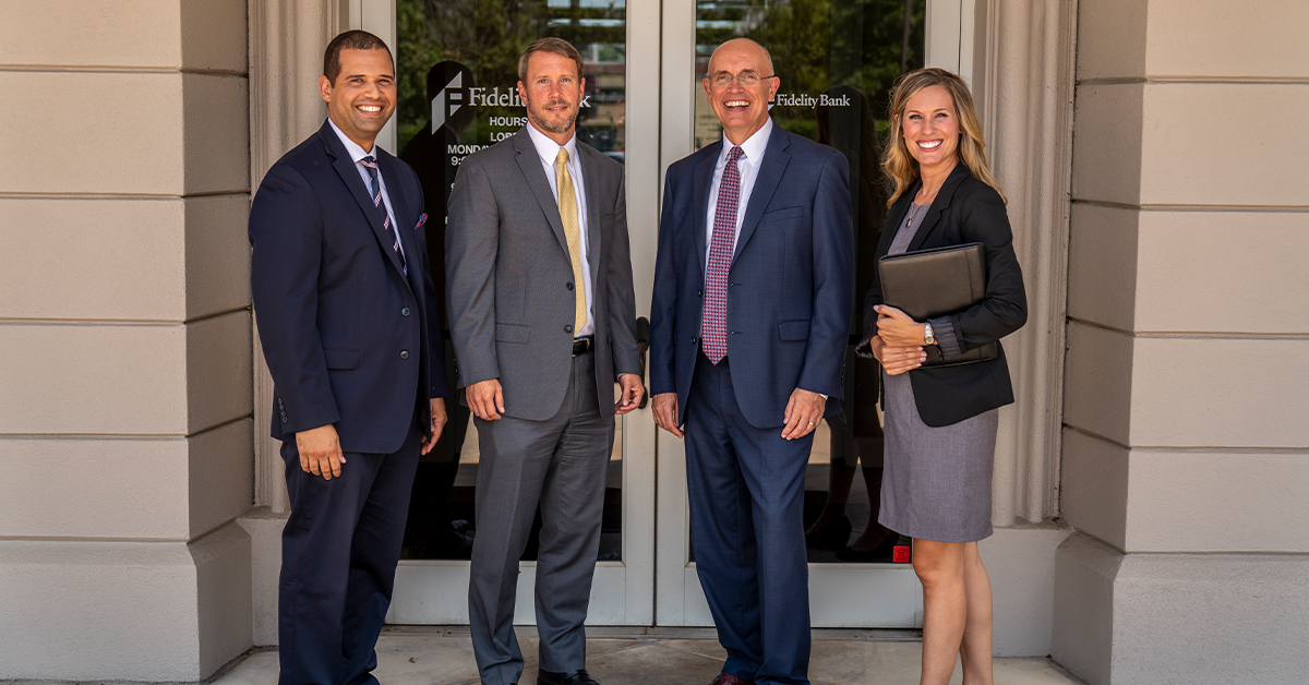 Fidelity Bank associates in front of branch doors