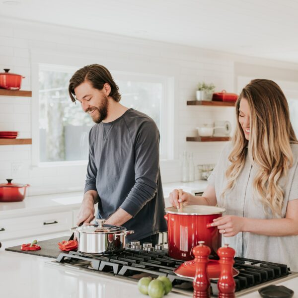 A couple cooking together in their kitchen, laughing