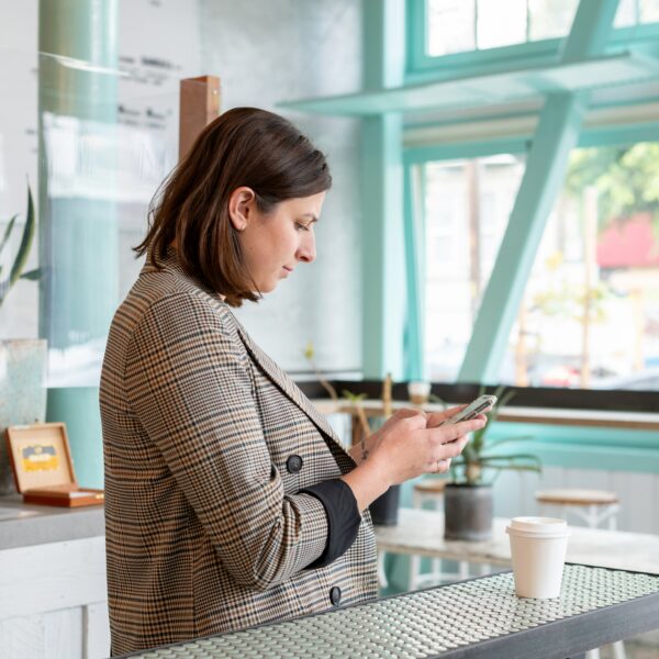 A woman at a cafe checking her phone