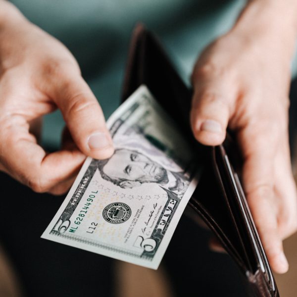 Hands pulling money out of a wallet