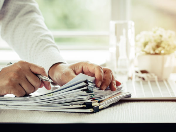 Hands carding through stacks of business paperwork