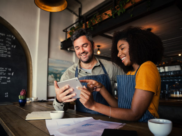 Two employees learn to use a tablet