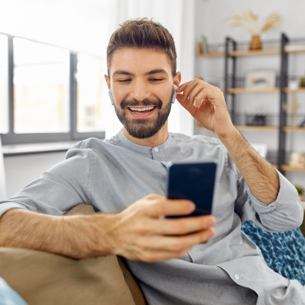 A man smiling joyously as he looks at his phone