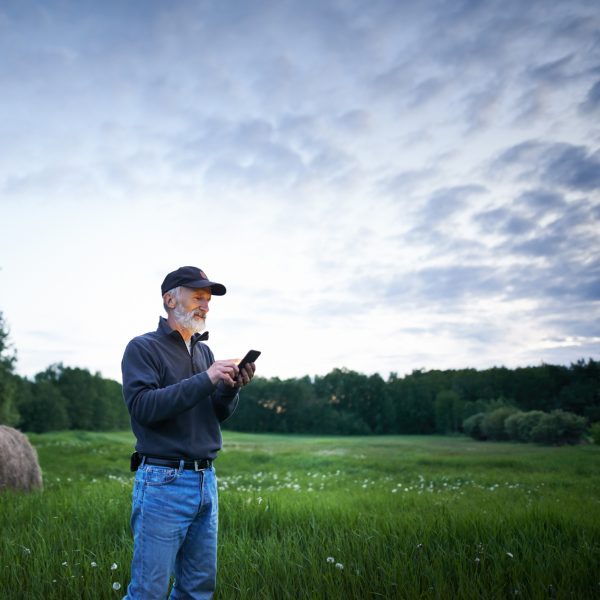 Shot of a mature man using a mobile phone while working on a farm