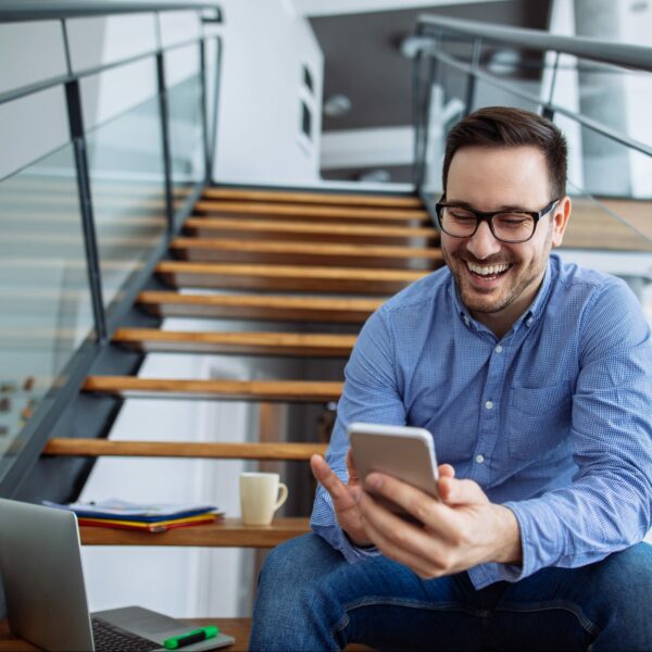 Businessman sitting on the stairs and text messaging