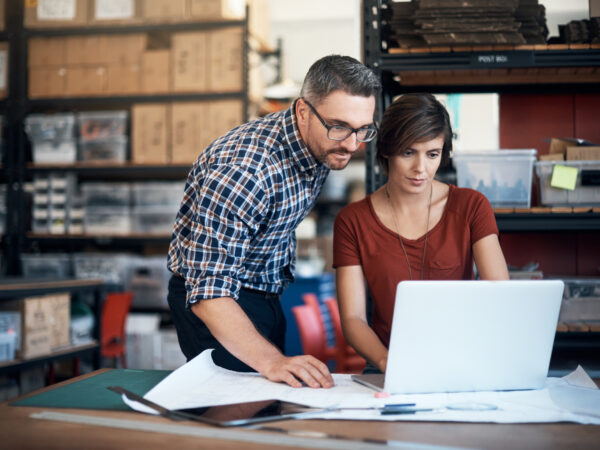 Shot of a man and woman using a laptop in a workshop