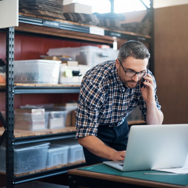 Shot of a man using a laptop and mobile phone