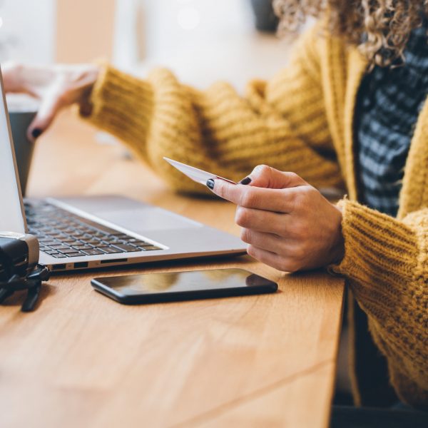 a woman online shopping with her credit card in her hand