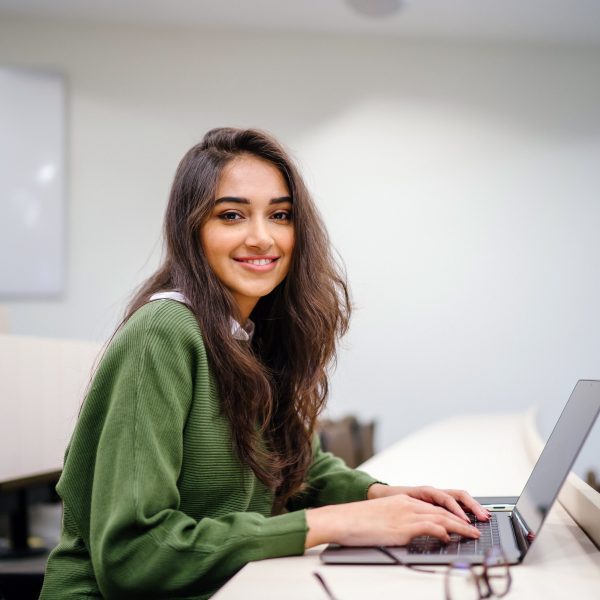 a student with her laptop in a classroom