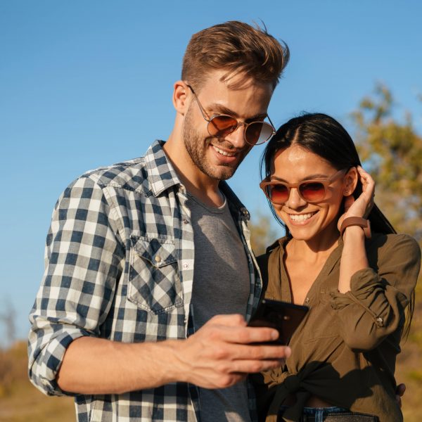 a couple looking at their phone while outside