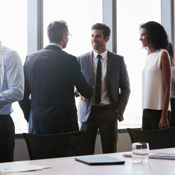 Office setting with men and women before a meeting