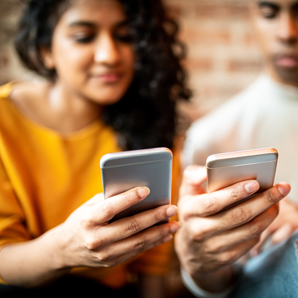 man and women looking at cell phones