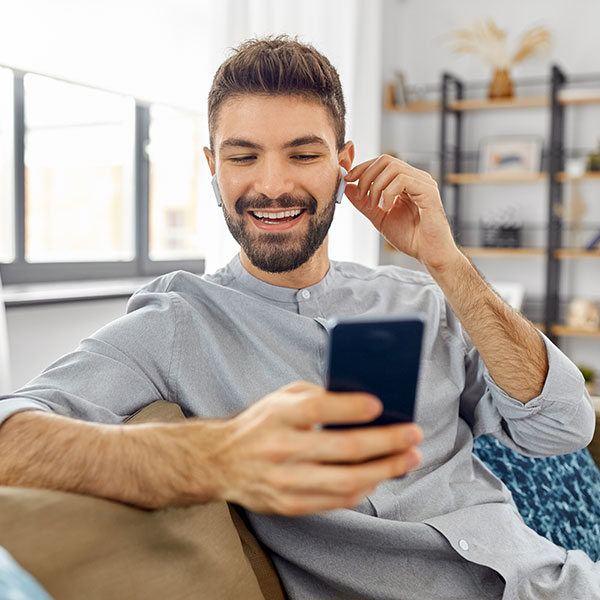 Man holding cell phone sitting on the couch