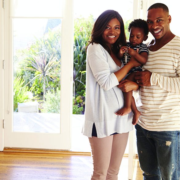 African American Couple Holding Baby with Keys to a new home