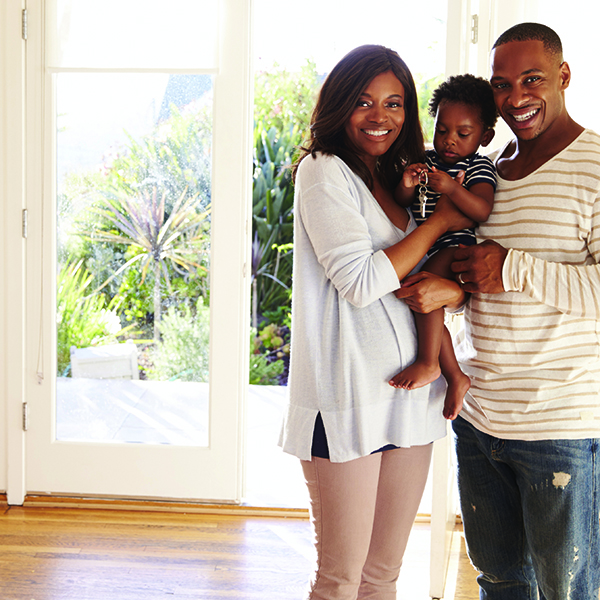 African American Couple Holding Baby with Keys to a new home