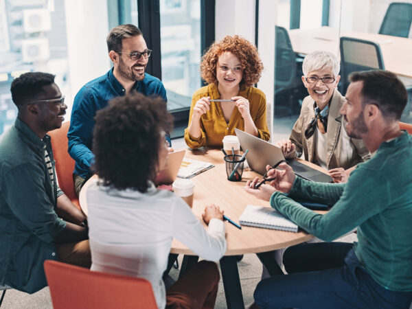 Mixed group of business people sitting around a table and talking