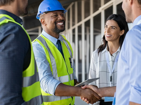 Construction worker shaking business man's hand