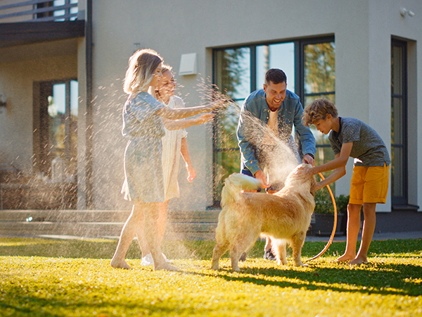 Family in yard and washing dog