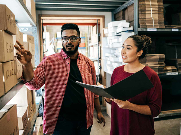 Business Owners in warehouse checking inventory