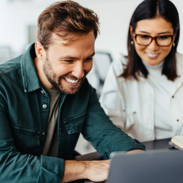 two people smiling at laptop