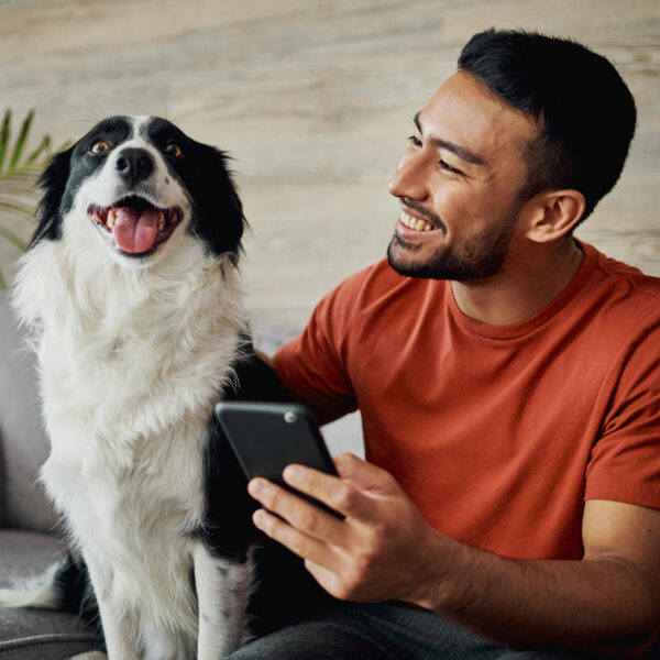 man on phone with dog next to him