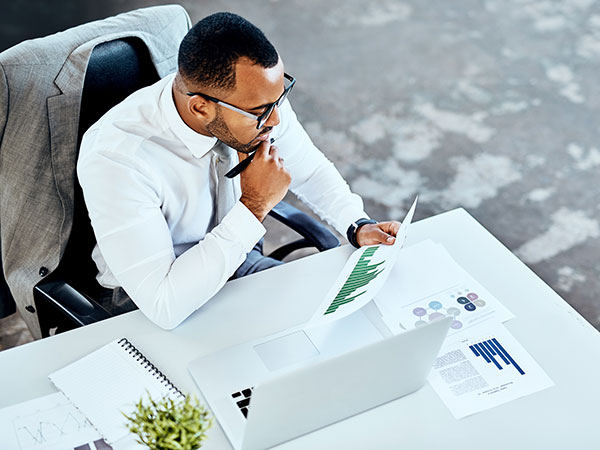 Businessman sitting at a desk reviewing printed documents