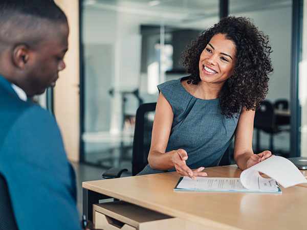 Smiling businesswoman meeting with a client at an office desk