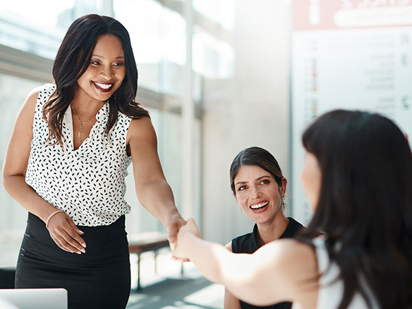Professional women greeting each other with a handshake